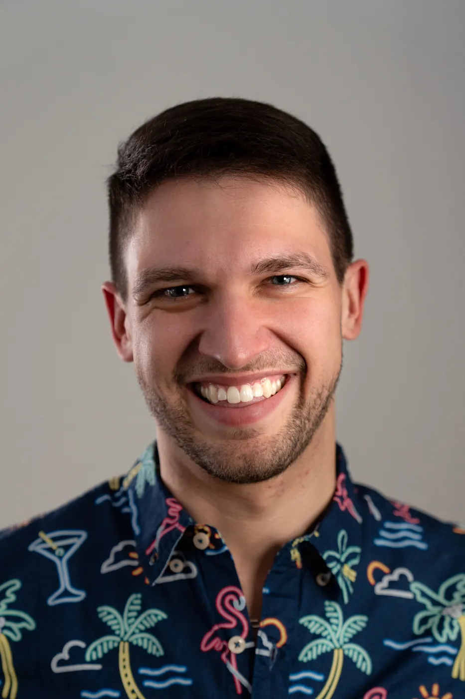 Headshot of a smiling man in a patterned shirt